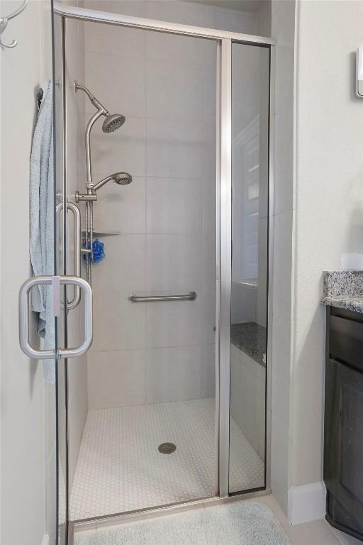 bathroom featuring a shower with shower door and vanity