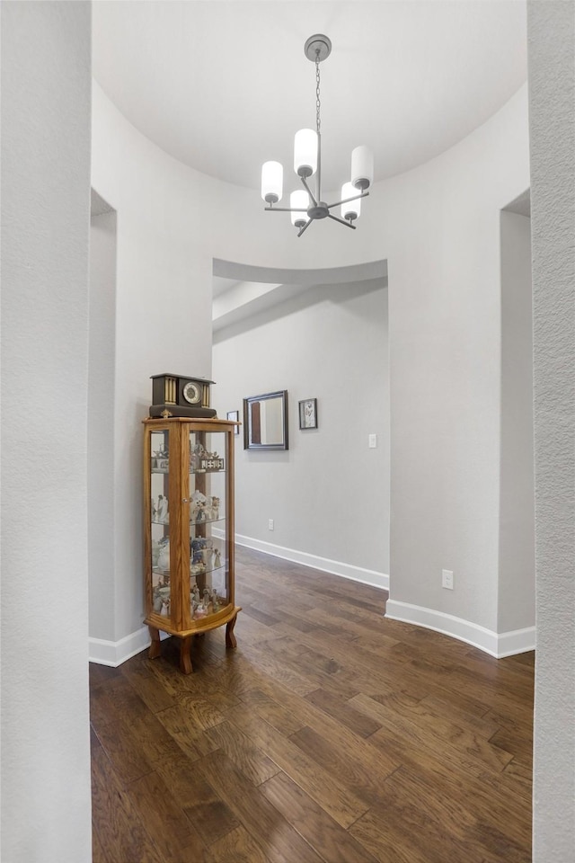 unfurnished dining area with an inviting chandelier and dark hardwood / wood-style floors