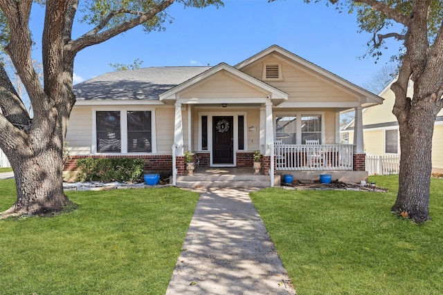 view of front of home featuring covered porch and a front lawn