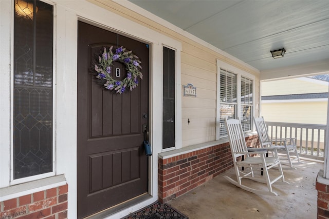 view of exterior entry featuring covered porch