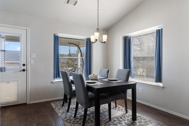 dining space with dark hardwood / wood-style floors, lofted ceiling, and an inviting chandelier