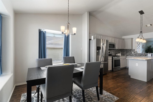 dining space with a notable chandelier, sink, dark hardwood / wood-style floors, and lofted ceiling