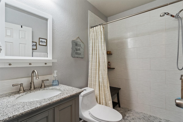 bathroom featuring toilet, vanity, and walk in shower