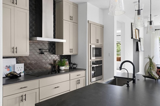 kitchen featuring sink, pendant lighting, oven, and wall chimney range hood