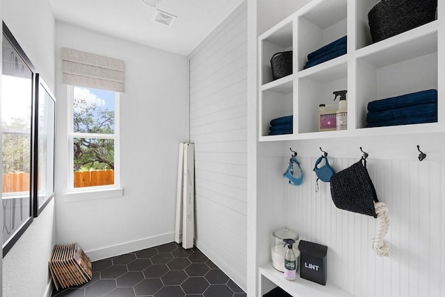 mudroom with dark tile patterned floors