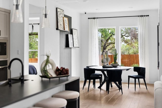 dining space with sink and light hardwood / wood-style floors