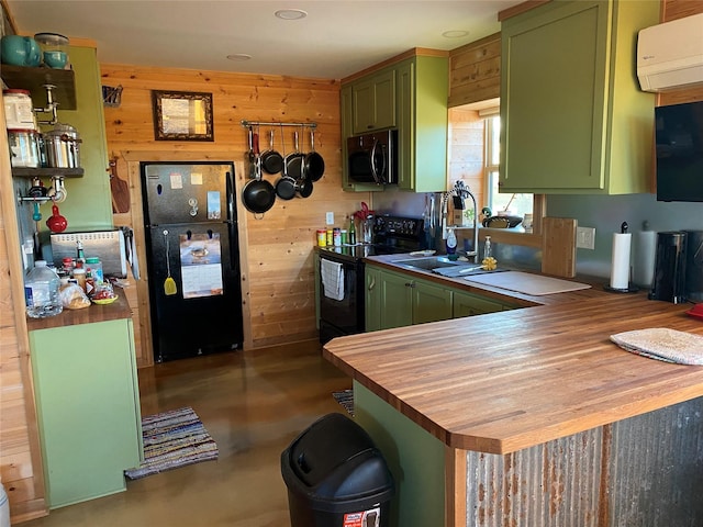 kitchen featuring kitchen peninsula, a wall unit AC, green cabinetry, wood walls, and black appliances