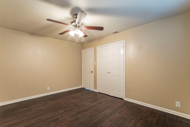 unfurnished bedroom featuring ceiling fan and dark hardwood / wood-style floors