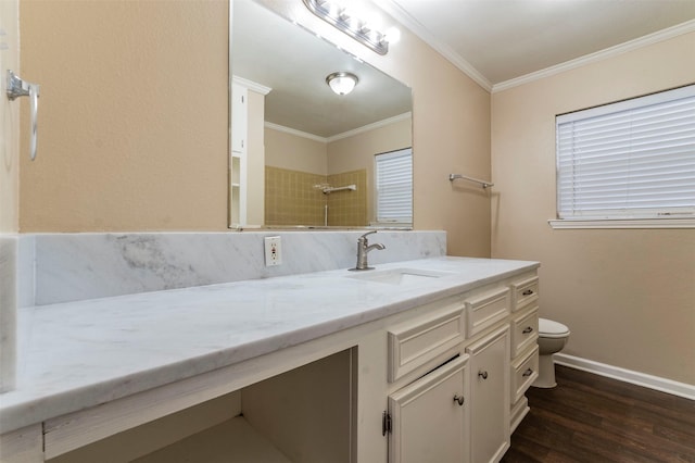 bathroom featuring toilet, crown molding, hardwood / wood-style floors, tiled shower, and vanity