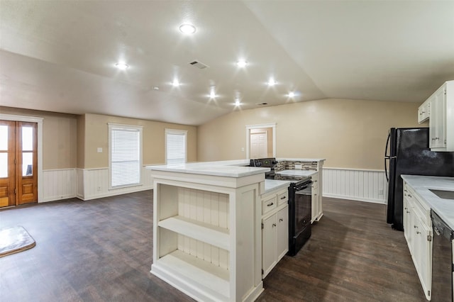 kitchen with black appliances, lofted ceiling, a kitchen island, dark wood-type flooring, and white cabinetry