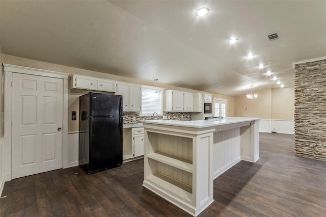 kitchen with white cabinetry, lofted ceiling, black appliances, and a center island