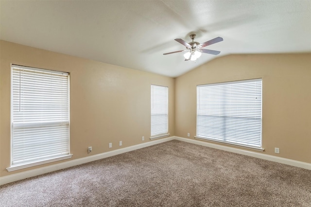 carpeted spare room with ceiling fan and vaulted ceiling