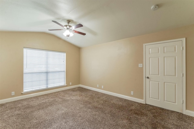 spare room with ceiling fan, a wealth of natural light, carpet flooring, and lofted ceiling