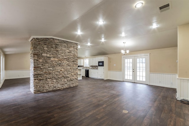 unfurnished living room featuring radiator heating unit, vaulted ceiling, dark hardwood / wood-style flooring, french doors, and an inviting chandelier