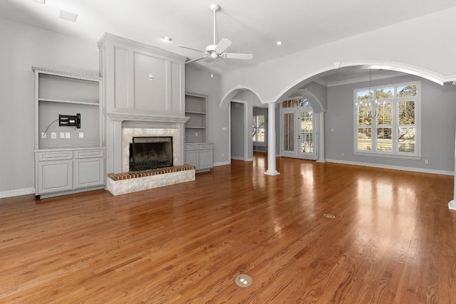 127 Roberts Cir, Georgetown, TX 78633 - unfurnished living room featuring ceiling fan, a high end fireplace, built in shelves, baseboards, and light wood-style floors