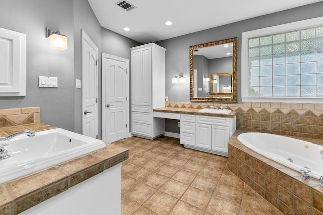 127 Roberts Cir, Georgetown, TX 78633 - full bath featuring two vanities, a whirlpool tub, recessed lighting, and tile patterned flooring