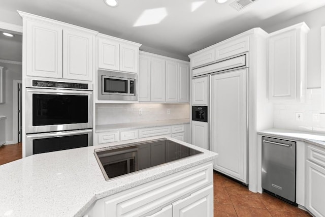 127 Roberts Cir, Georgetown, TX 78633 - kitchen with built in appliances, recessed lighting, decorative backsplash, white cabinetry, and light stone counters