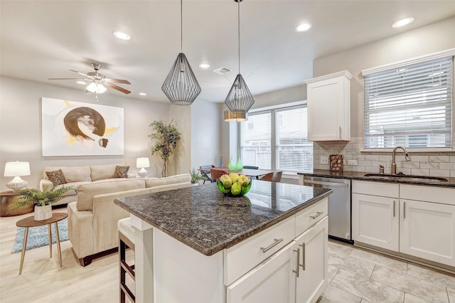 kitchen featuring pendant lighting, sink, white cabinetry, and dishwasher