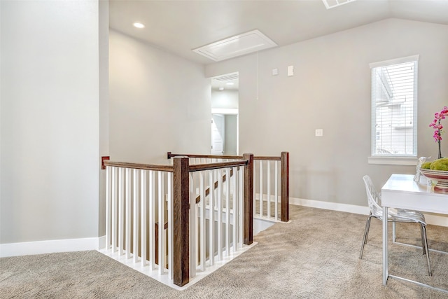 hallway with light colored carpet and vaulted ceiling