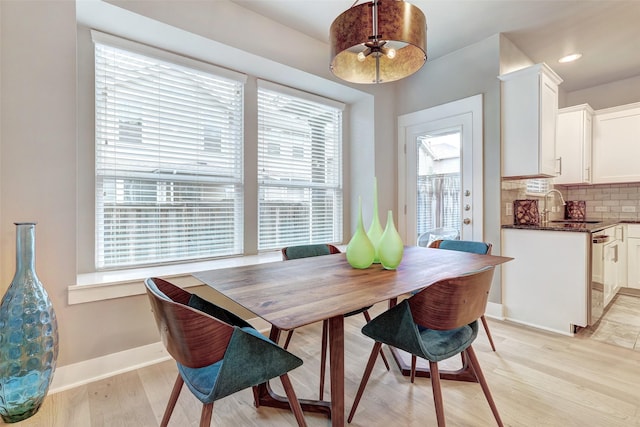 dining space with light wood-type flooring and sink