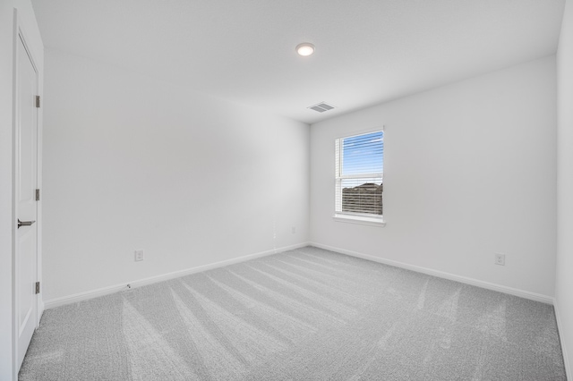 unfurnished room with baseboards, visible vents, and light colored carpet