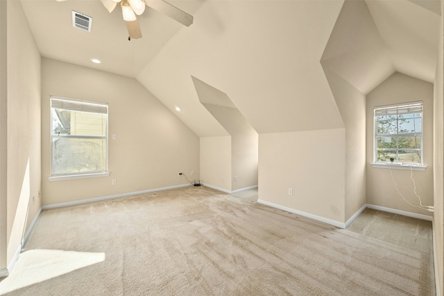 additional living space with vaulted ceiling, light carpet, and ceiling fan