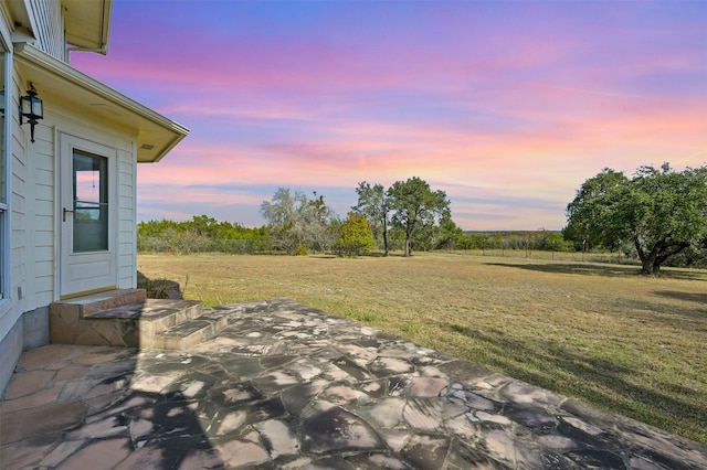 yard at dusk featuring a patio area