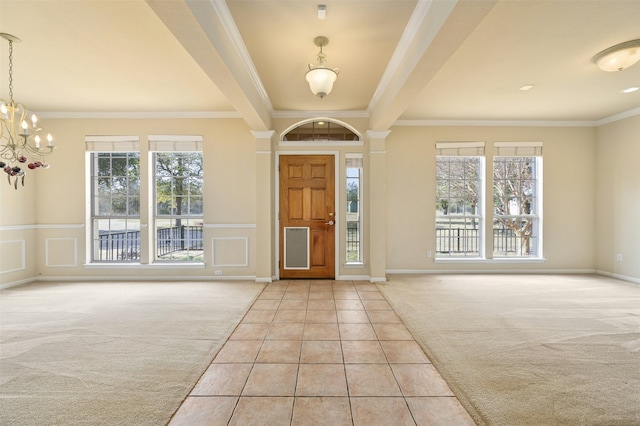 foyer with ornamental molding, a healthy amount of sunlight, and light tile patterned floors