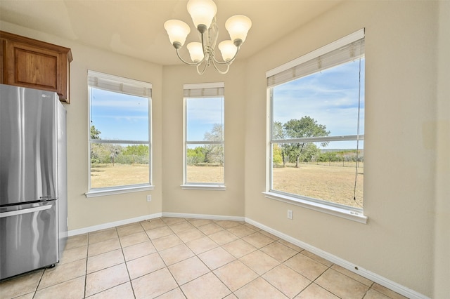 unfurnished dining area with a chandelier and light tile patterned floors