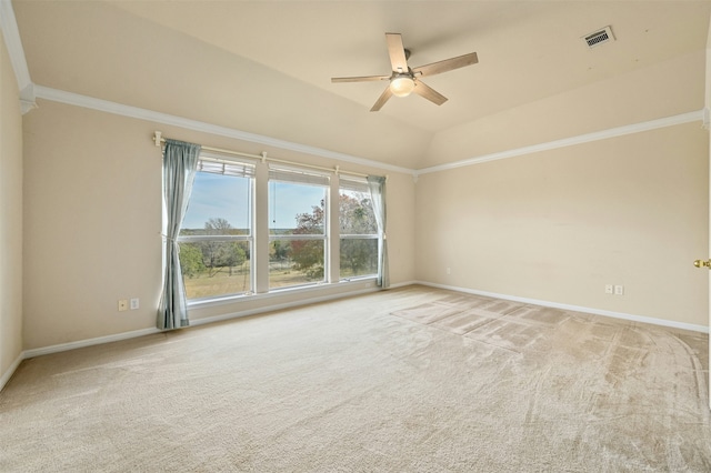 carpeted empty room with vaulted ceiling, crown molding, and ceiling fan