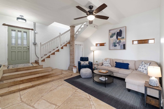 living room featuring beam ceiling, stairway, stone finish floor, and ceiling fan