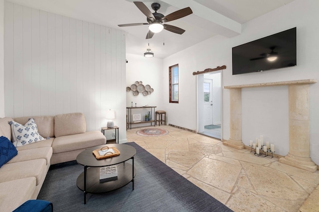 living room featuring decorative columns, ceiling fan, wood walls, and beam ceiling