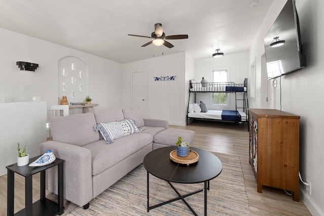 living room with a ceiling fan, wood finished floors, and baseboards