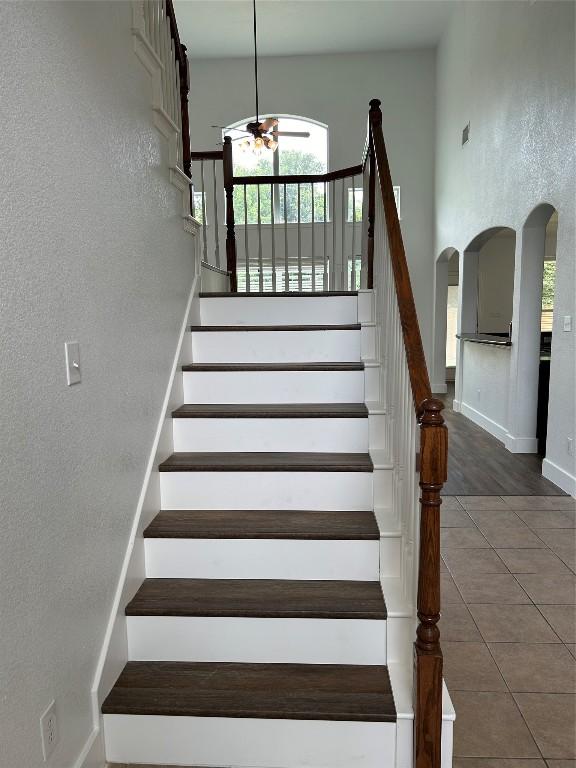 stairs featuring tile patterned flooring and ceiling fan