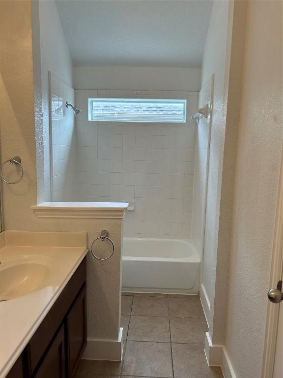 bathroom featuring vanity, tile patterned floors, and tiled shower / bath