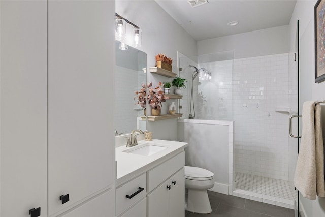 bathroom featuring vanity, a shower with shower door, tile patterned floors, and toilet