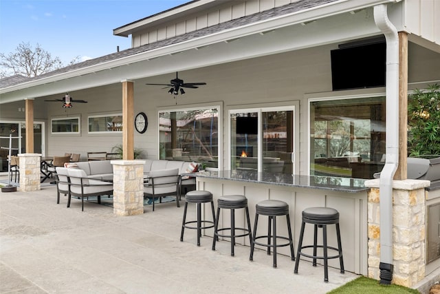 view of patio with ceiling fan and a bar