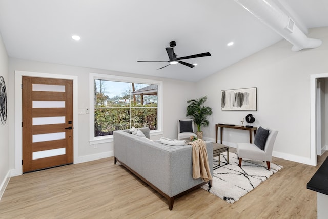 living room featuring ceiling fan, vaulted ceiling, and light wood-type flooring