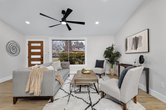 living room featuring ceiling fan, lofted ceiling, and light wood-type flooring