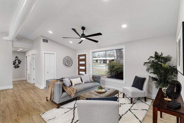 living room featuring ceiling fan, vaulted ceiling, and light wood-type flooring