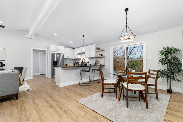 dining room featuring light hardwood / wood-style floors and lofted ceiling with beams