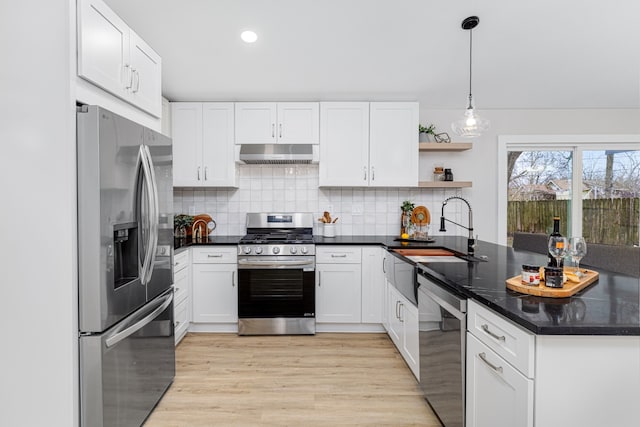 kitchen with white cabinetry, decorative backsplash, hanging light fixtures, kitchen peninsula, and stainless steel appliances