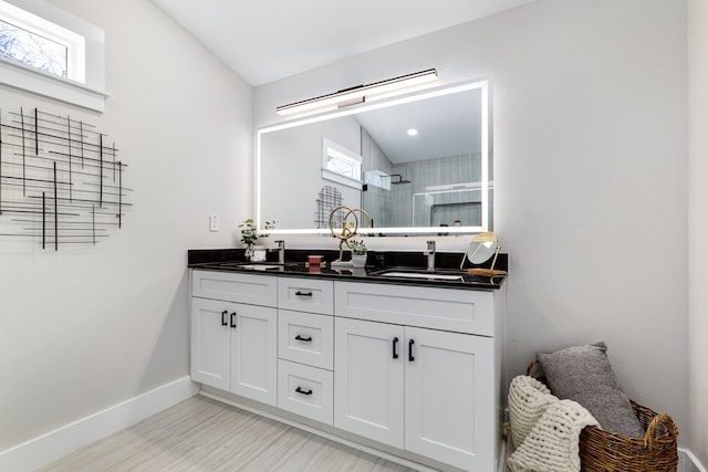 bathroom featuring lofted ceiling, vanity, and walk in shower