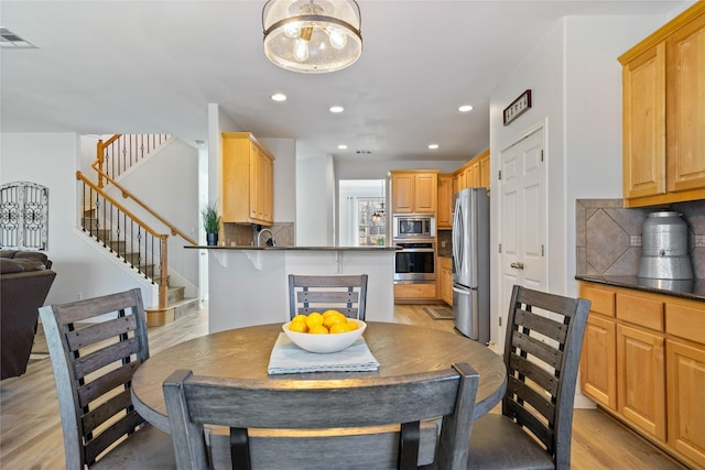 dining room featuring sink and light hardwood / wood-style flooring