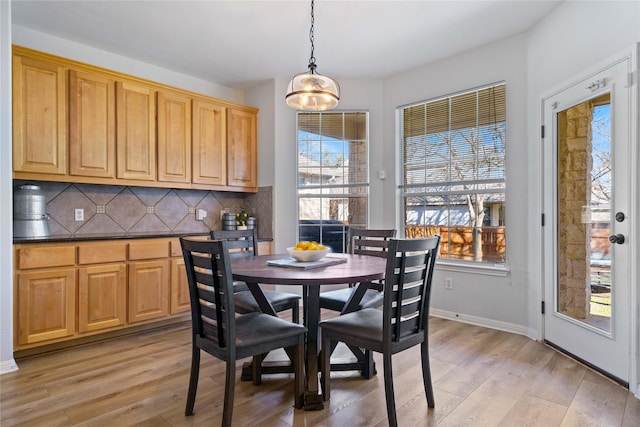 dining space featuring baseboards and light wood finished floors