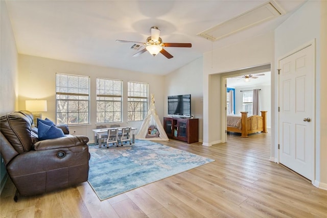 living area with visible vents, attic access, a ceiling fan, light wood-type flooring, and baseboards