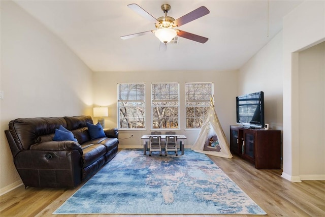 living room with lofted ceiling, wood finished floors, a ceiling fan, and baseboards