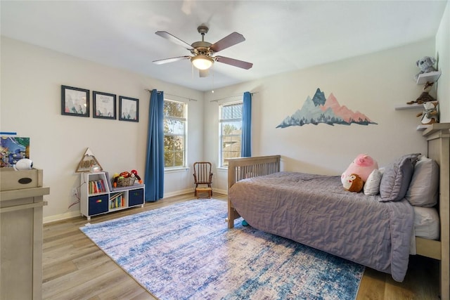 bedroom featuring ceiling fan, light wood finished floors, and baseboards