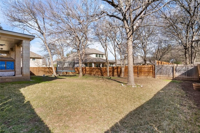 view of yard featuring a fenced backyard and a trampoline