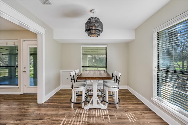 dining area with a healthy amount of sunlight and dark hardwood / wood-style floors